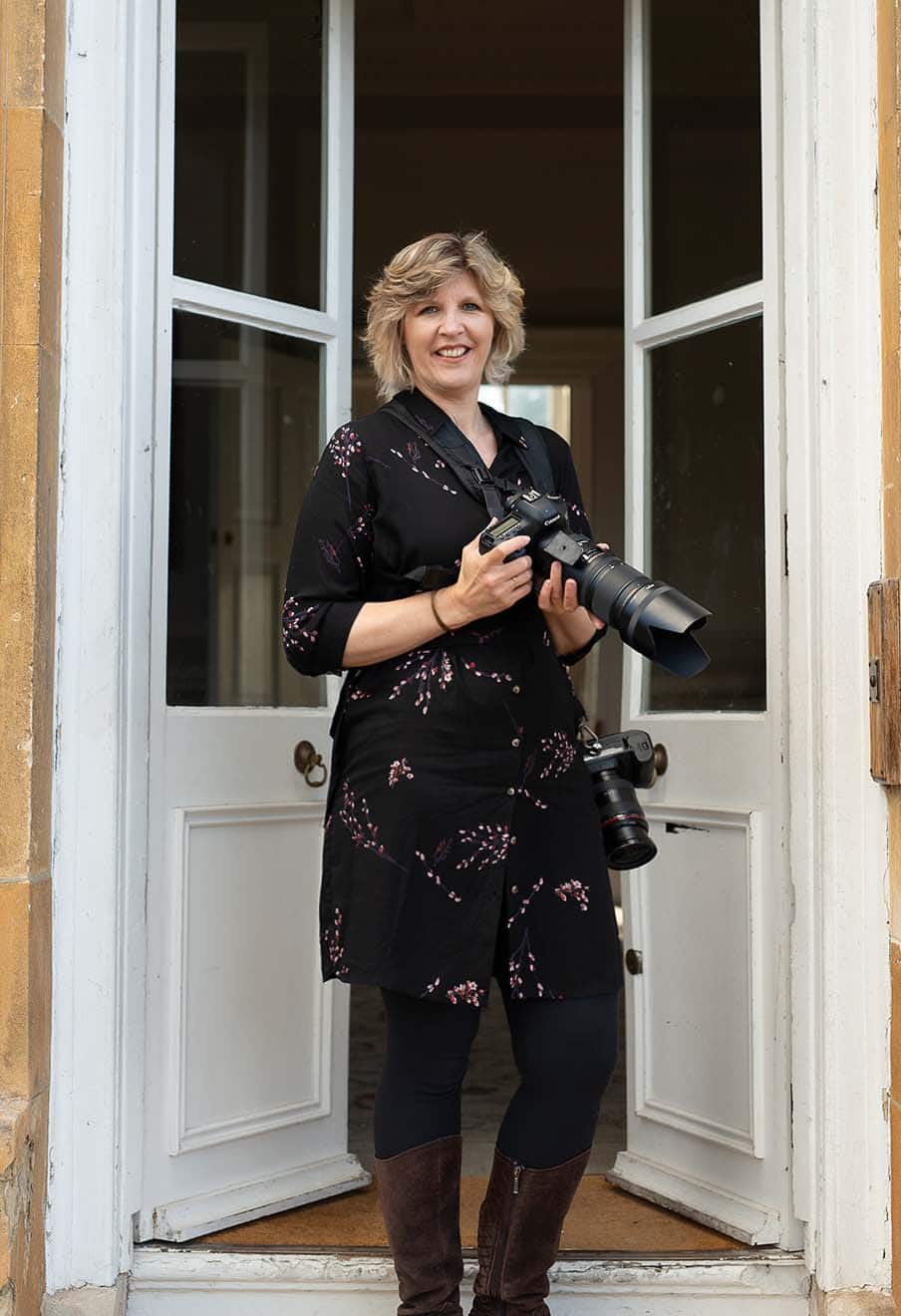 A photograph of Victoria Welton with her camera. She is an award-winning Somerset Wedding Photographer.