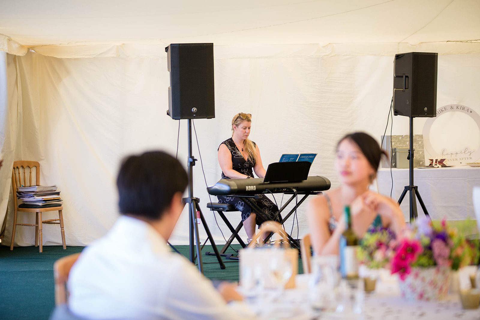 A photograph of a woman playing a piano at a wedding reception.